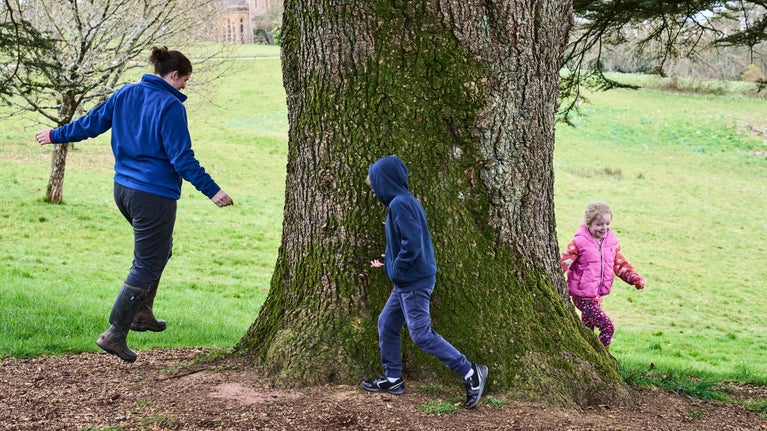Visitors using the Stranger Folk app try wassailing near a tree at Knightshayes, Devon